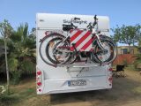 In some places, such as Spain and Italy, you will be obliged to display a red and white diagonal-striped warning sign on protruding loads, for example, bikes
