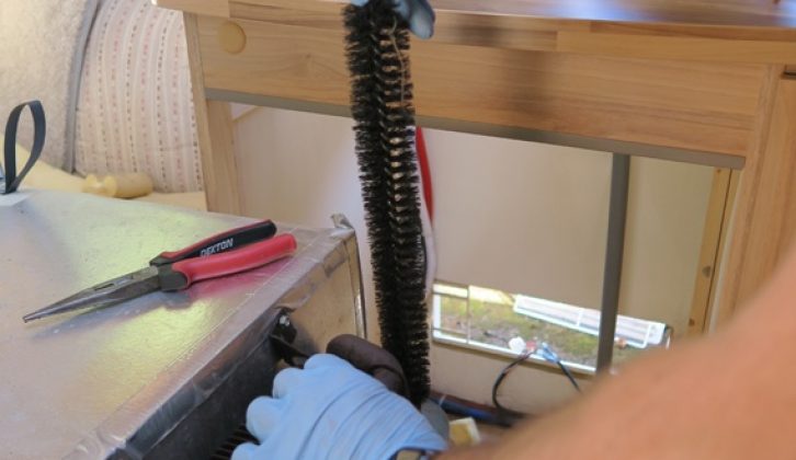 A purpose-made wire brush helps to rid flue of its sooty deposits