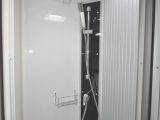 The shower cubicle has a tambour door and plastic lining