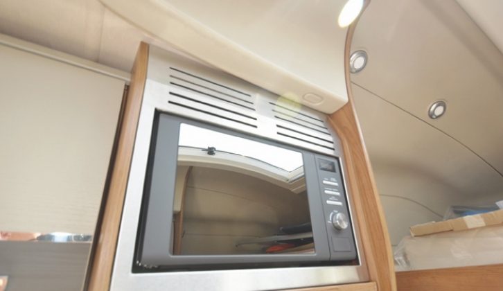 The microwave is neatly housed directly over the hob