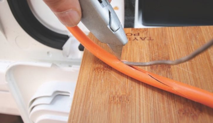 Cut carefully along the length of the orange cable