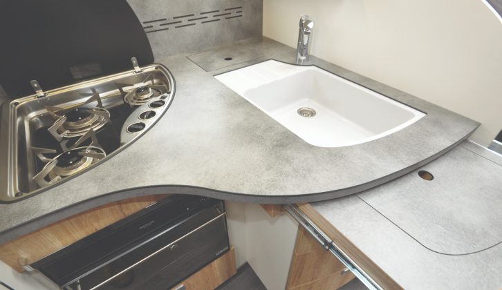 The kitchen is small, but smart. That slide-out worktop uses the cover for the sink and drainer to extend available work surface