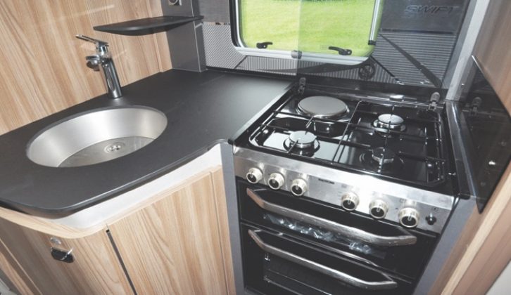 The L-shaped kitchen has a full cooker and useful details such as a shelf beyond the mixer tap