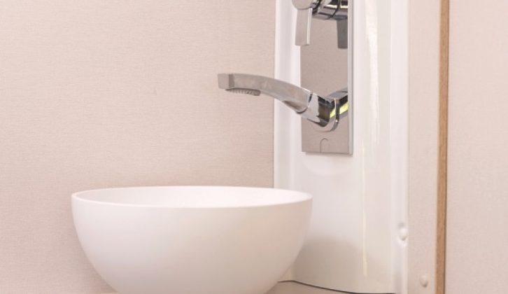 The shower extends out from the large salad bowl-style handbasin in the corner of the washroom, and you also get a towel hook