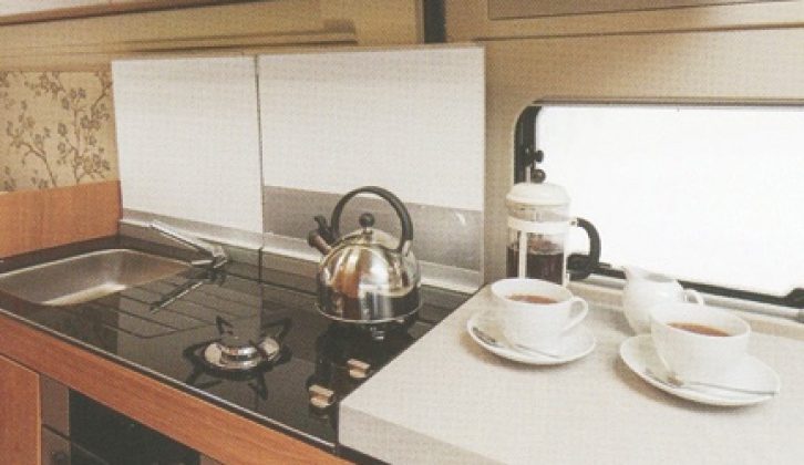 The designer kitchen had gloss-black toughened glass cover/worktop over hob and sink