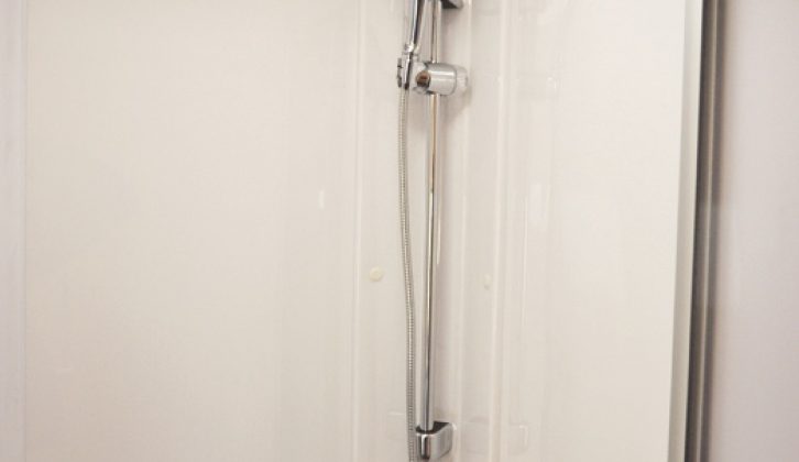 The shower cubicle has full plastic lining and a height-adjustable showerhead