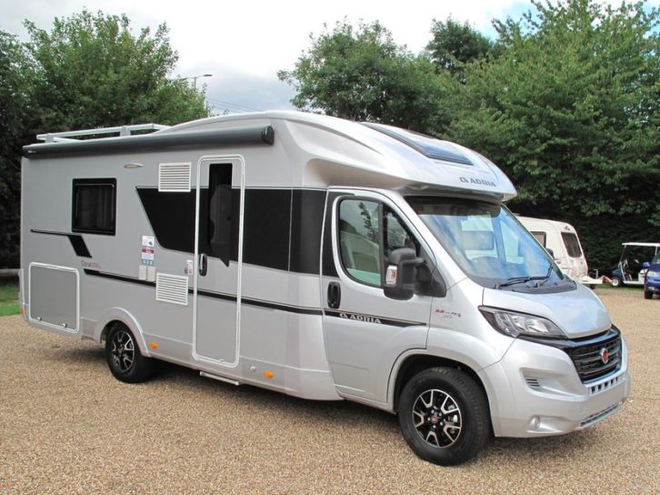 Adria Coral Supreme 670 SLT parked on gravel with a caravan in the background
