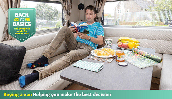 A man reading a book in a motorhome lounge