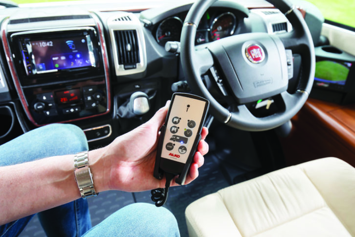 A remote control being held in the cab of a motorhome