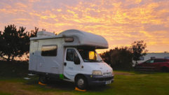 A parked motorhome by the setting sun