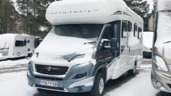 A motorhome with snow on the windscreen and snow on the ground