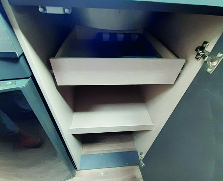 Kitchen storage includes a shelved cupboard underneath the sink