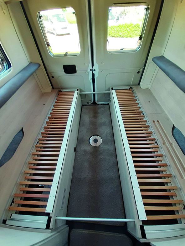 Two metal rods fit across the aisle to create the bed