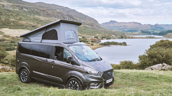 The Swift Monza with the roof up, parked on grass against a scenic back backdrop