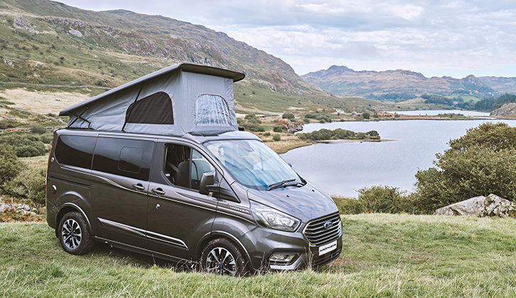 The Swift Monza with the roof up, parked on grass against a scenic back backdrop