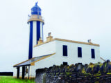 Uniquely striped lighthouse at Start Point dominates the coastal skyline
