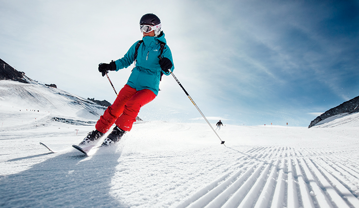 A person skiing wearing bright clothing