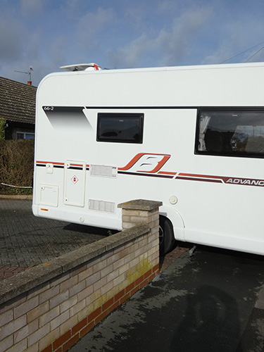 A motorhome emerging from a narrow opening
