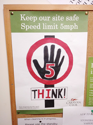 A 5mph speed limit sign attached to a notice board