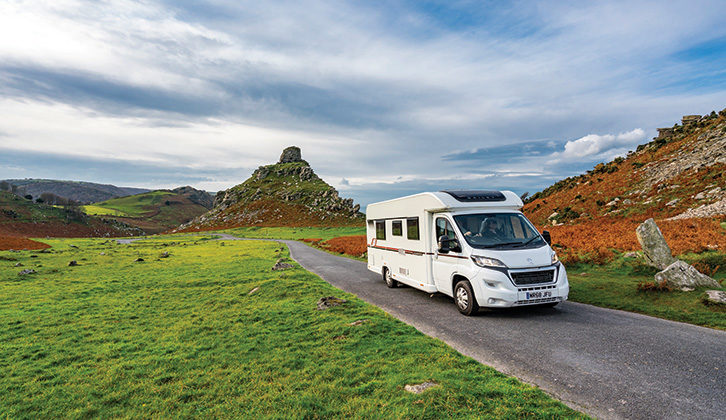 A motorhome driving along, with beautiful scenery in the background