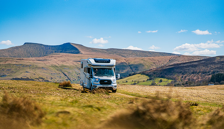 A motorhome driving down a scenic road