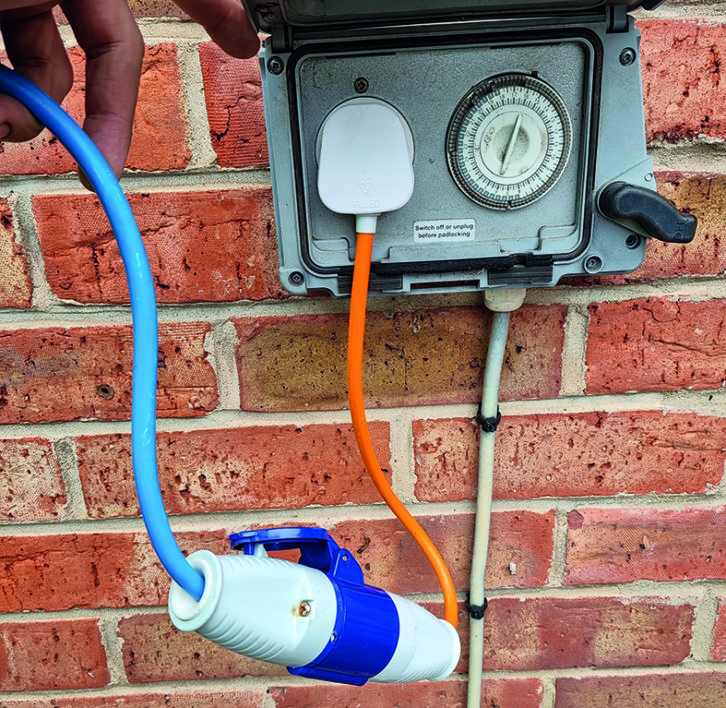 It's simplest to have a waterproof outdoor mains socket fitted and use a three-ping to CEE plug adaptor