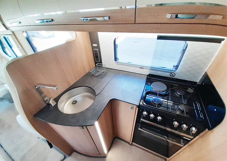 The kitchen in the Auto-Trail Grand Frontier GF 88 includes a convincing slate-like worktop and overhead lockers