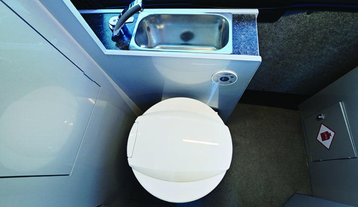 'Washroom' zone provides a Dometic electric-flush toilet, deep stainless-steel handbasin and a hot water supply