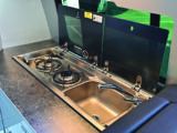 Kitchen is small but well designed, with a Dometic two-burner hob and combined sink both fitted with glass covers