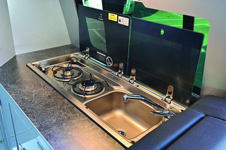 Kitchen is small but well designed, with a Dometic two-burner hob and combined sink both fitted with glass covers