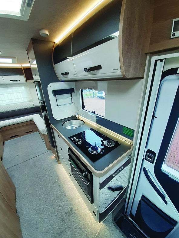 Kitchen is well-lit and three-burner hob includes an induction plate, ut the work surface area is a little limited