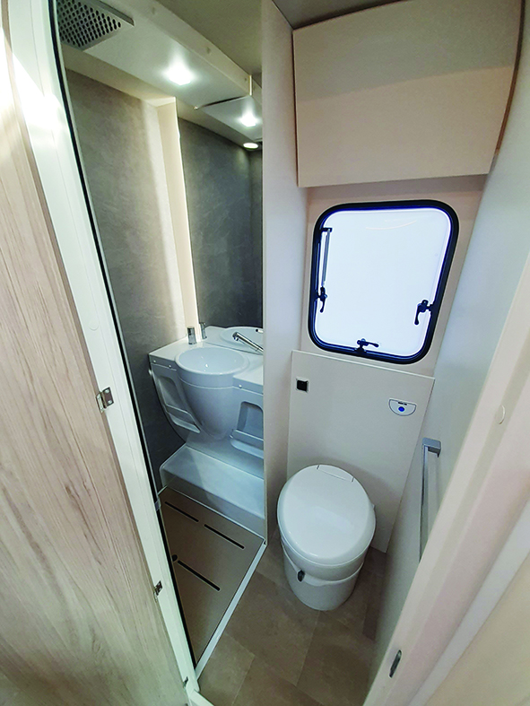 Washroom houses a rain shower, mirror and handbasin
