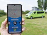 A mobile phone tracking the campervan in the background