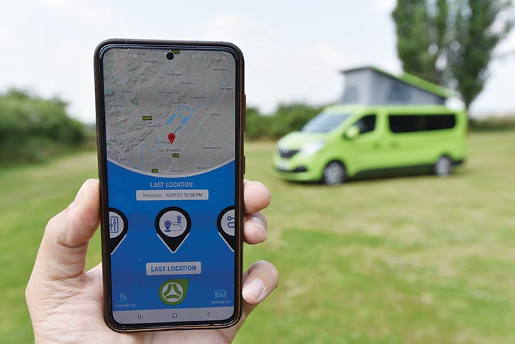 A mobile phone tracking the campervan in the background