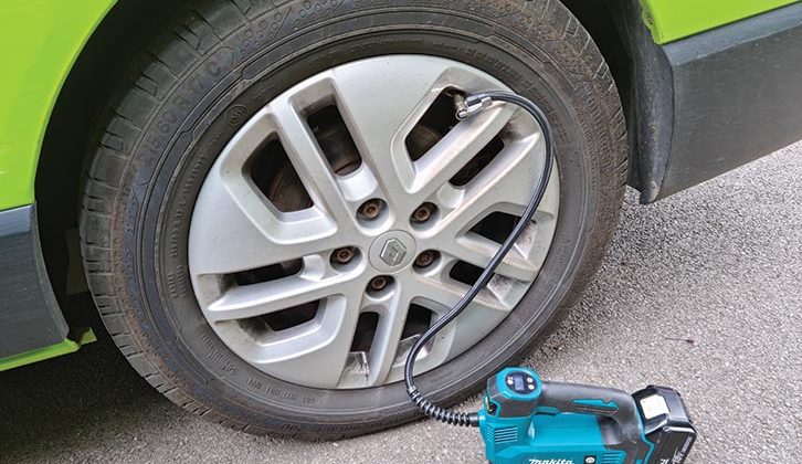 A drill battery-powered tyre inflator at work