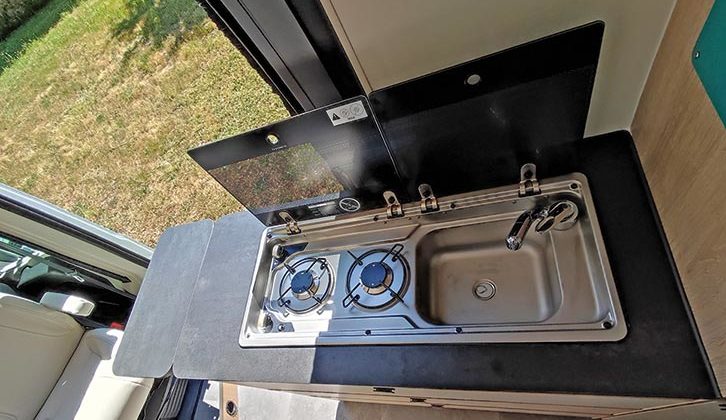 The compact kitchen provides a two-burner hob and small sink