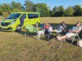 3 people and 2 dogs relax on site