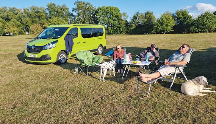 3 people and 2 dogs relax on site