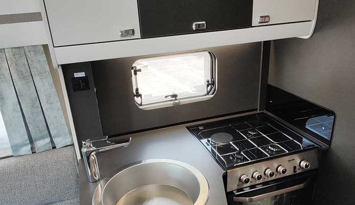 Four-burner hob and sink in kitchen