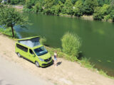 Campervan pitched by water