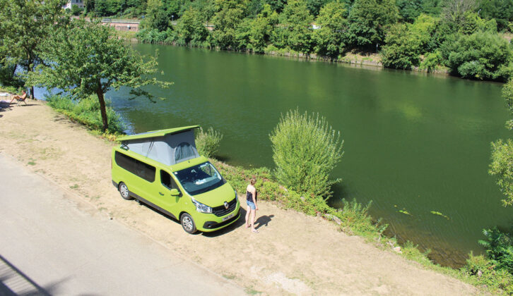 Campervan pitched by water