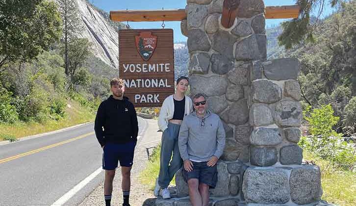 Family by Yosemite National Park sign