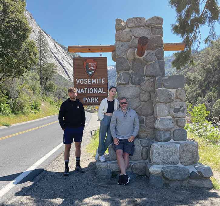 Family by Yosemite National Park sign