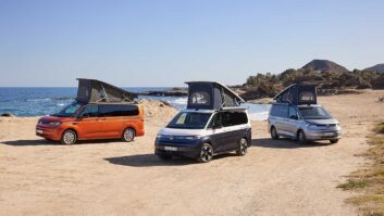 Three VW California models on a beach with pop-up roofs up