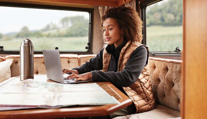 A woman on a laptop in a campervan