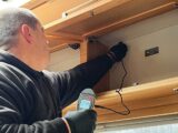 Damp being tested for in a cupboard