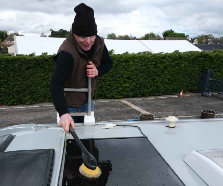 Using a short-handled brush on the roof