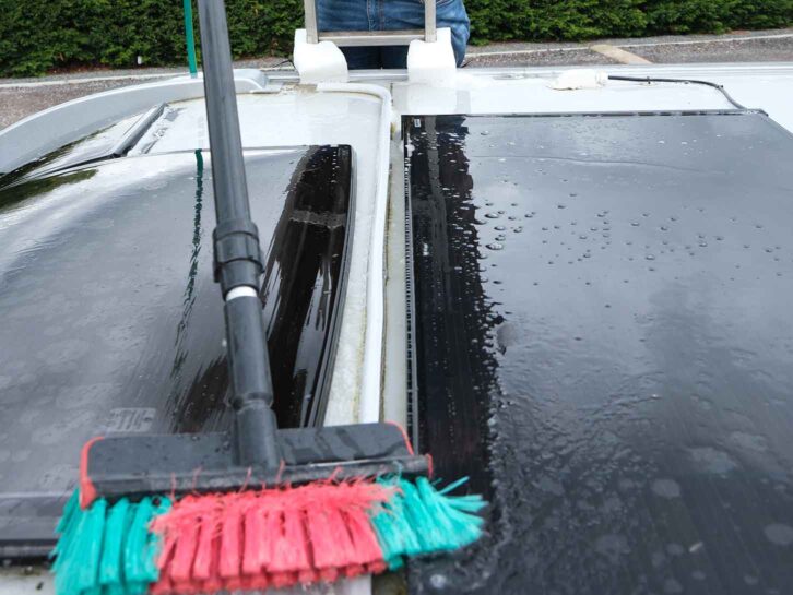 Using a long-handled brush to clean the motorhome roof
