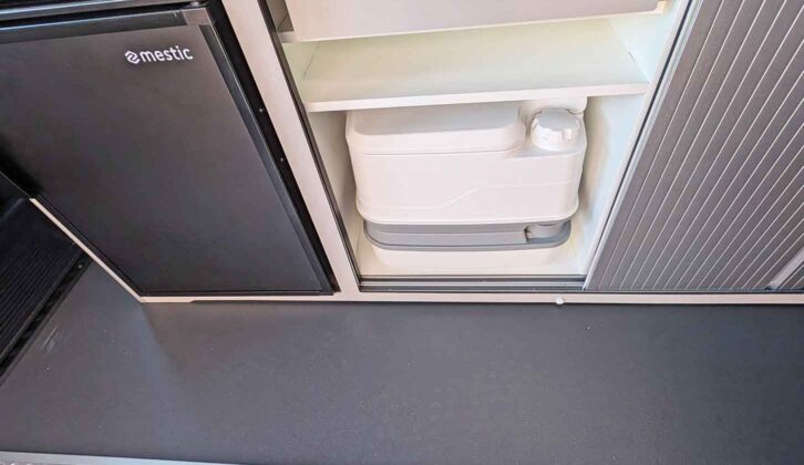 A Porta Potti being stored in a cupboard