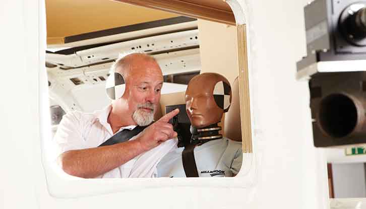 A man and a dummy both with their seatbelts on
